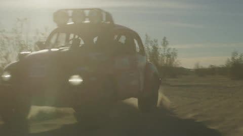 A Man Drives a Rally Car Through the Desert