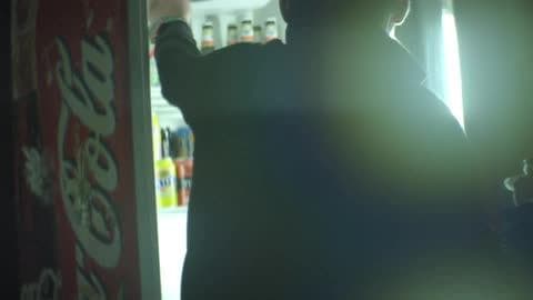 A Man Opens a Retail Refrigerator to Grab a Beverage
