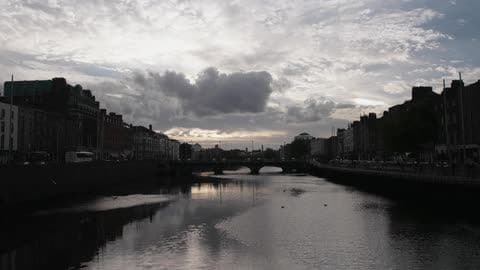 Birds Fly Over the Water Under a Cloudy Sky