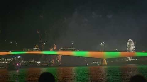People Are Watching a Fireworks Display at Night from a Boat on a River