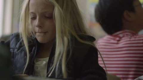 A Child Shoving Another Child'S Hand And Grabbing An Object