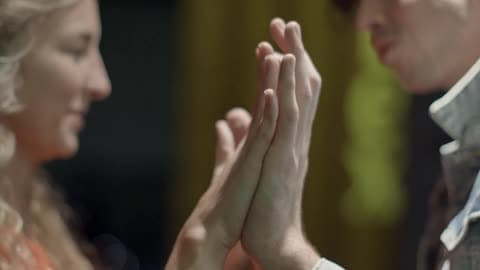 A Man And Woman Facing Each Other Are Holding Their Hands Out Palms Forward Touching Their Palms Together