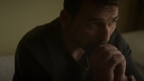 A Man Sits With His Chin On His Hands