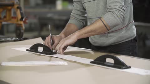 A Man Traces On A Large Piece Of Paper