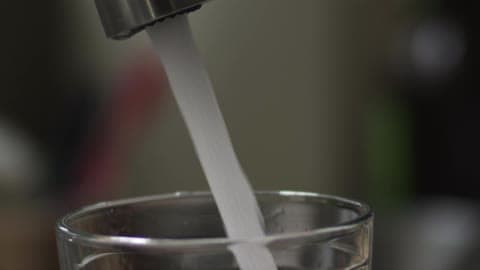 A Person Turning On A Faucet