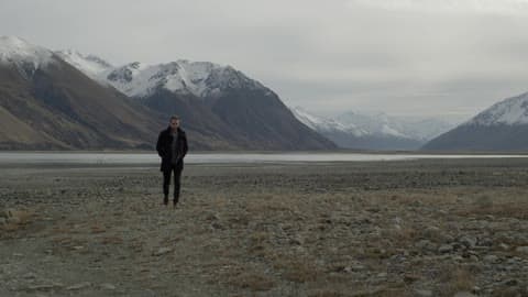 A Person Walking Away From A Mountain