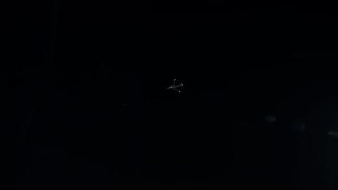 A Plane Flies In A Dark Night Sky