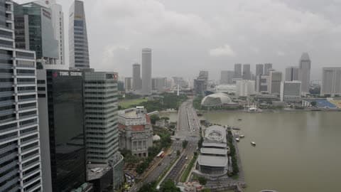 A View Of A City On A Harbor With Tall Buildings And Traffic On A Street
