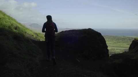 A Woman Hikes And Stops To Take A Photograph