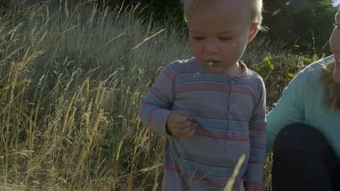 A Young Boy Enjoying His Outdoor Time With His Mother On A Sunset Evening In The Woods Exploring