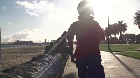 Boy Running Down A Stone Path By The Beach