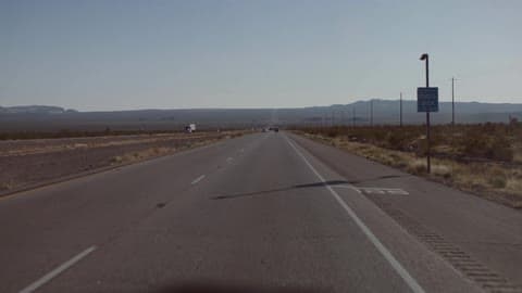 Car Drives Down Desert Road