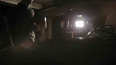 Man Shaking A Can Of Spray Paint Next To A Car