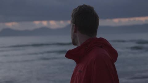 Man Standing On The Beach Looking At The Water